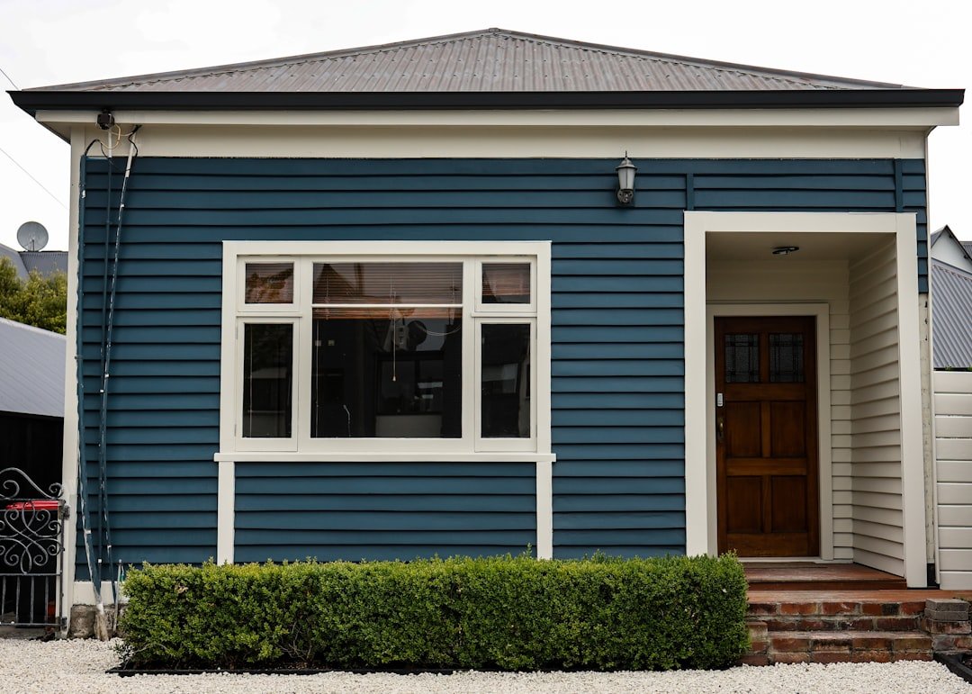 A blue house with white trim and a brown door